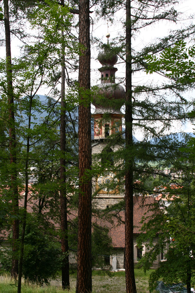De markante, schilderachtige barokke toren van de Rainkirche, die aan de onder de slotheuvel staat, laat zich door de bomen wat moeilijk fotograferen.