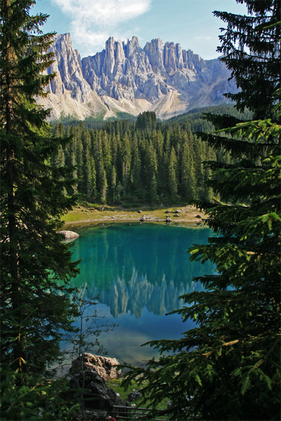 Terwijl andere meren in de Dolomieten een blauwe, groene of blauwzwarte waterspiegel bezitten, gloeit het Lago di Carezza met aquamarijn en rood, doorsneden door goudgele banden.