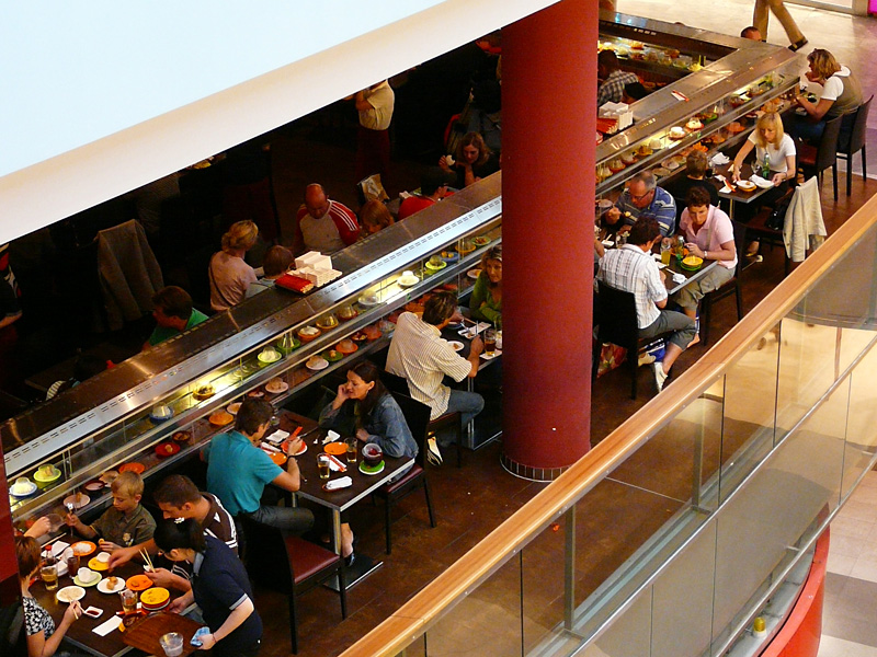 Op de eerste verdieping is een restaurant te vinden met de naam 'Running Sushi' waar Japanse lekkernijen op een lopende band langs je tafeltje komen.