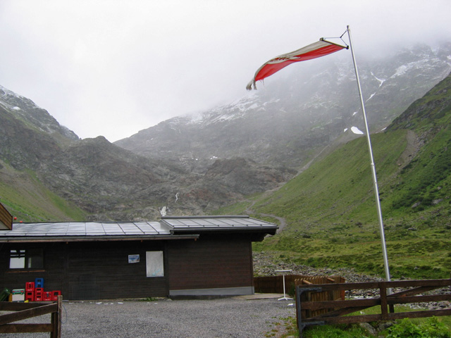 Net voordat we bij de hut Gletscher Stüberl (1915m) zijn, begint het flink te regenen en trekt de wind nog eens extra aan.